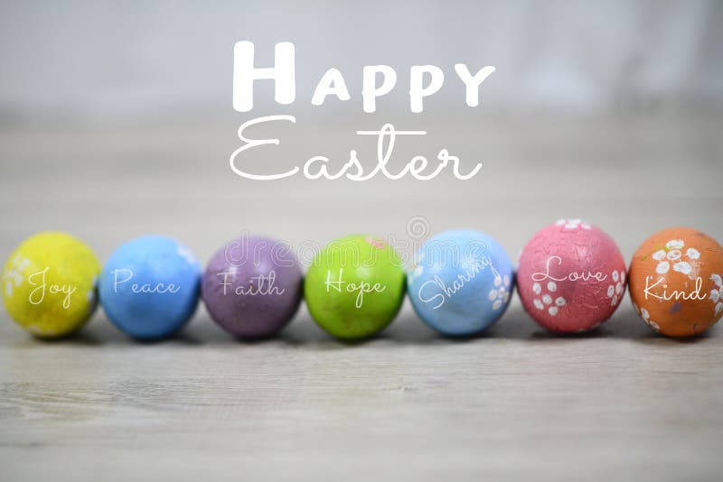 Happy Easter. Bright and soft colorful Easter eggs lined up horizontally on a white wooden background. Easter egg with kind and positive single word on it. Easter holiday card and greeting concept. Happy Easter. Bright and soft colorful Easter eggs lined up horizontally on a white wooden background. Easter egg with kind and positive single word on it. Easter holiday card and greeting concept.