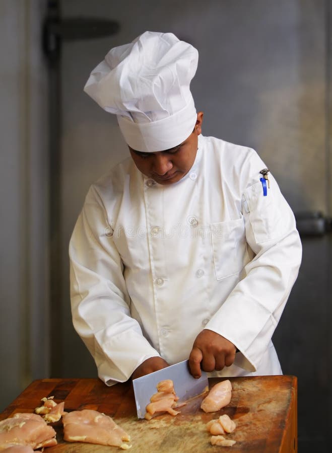 Chef cutting meat looking from front. Chef cutting meat looking from front