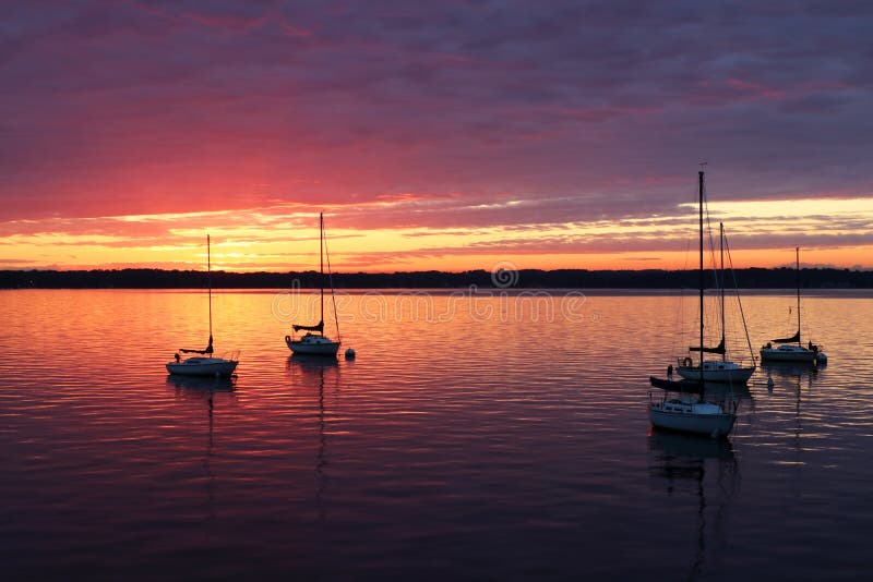 Szenische Ansicht von silhouettierten Yachten gegen buntes nach Sonnenuntergang stockfotografie Szenische Ansicht von silhouettierten Yachten gegen buntes nach Sonnenuntergang stockfotografie