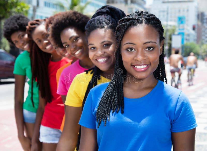 Six beautiful african american women in line in colorful shirts in the summer in the city. Six beautiful african american women in line in colorful shirts in the summer in the city