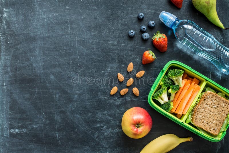 Szkolnego lunchu pudełko z kanapką, warzywami, wodą i owoc