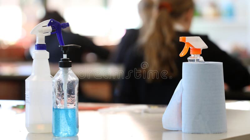 Covid safe school. Inside a classroom with cleaning products on display such as hand sanitizer, disinfectant, paper towel on a desk. Corona virus issues and impact. Covid safe school. Inside a classroom with cleaning products on display such as hand sanitizer, disinfectant, paper towel on a desk. Corona virus issues and impact