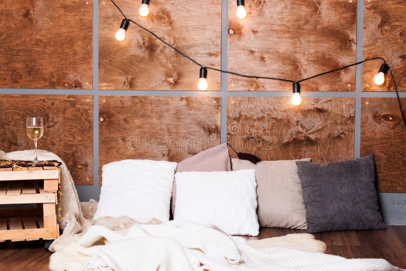 Szkło biały wino w nowożytnym loft wnętrzu z lekką girlandą na drewnianej ścianie fotografia stock Szkło biały wino w nowożytnym loft wnętrzu z lekką girlandą na drewnianej ścianie fotografia stock