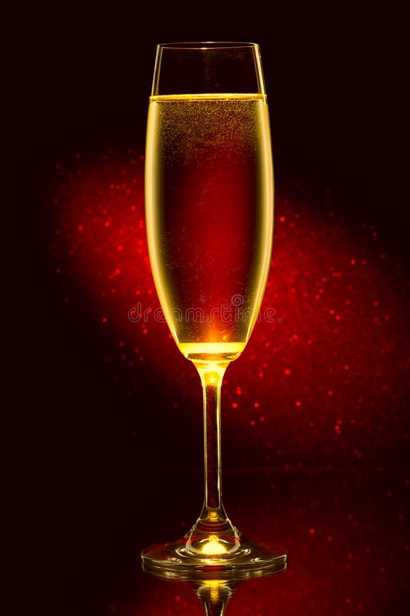 Glass of champagne against a red background. Glass of champagne against a red background