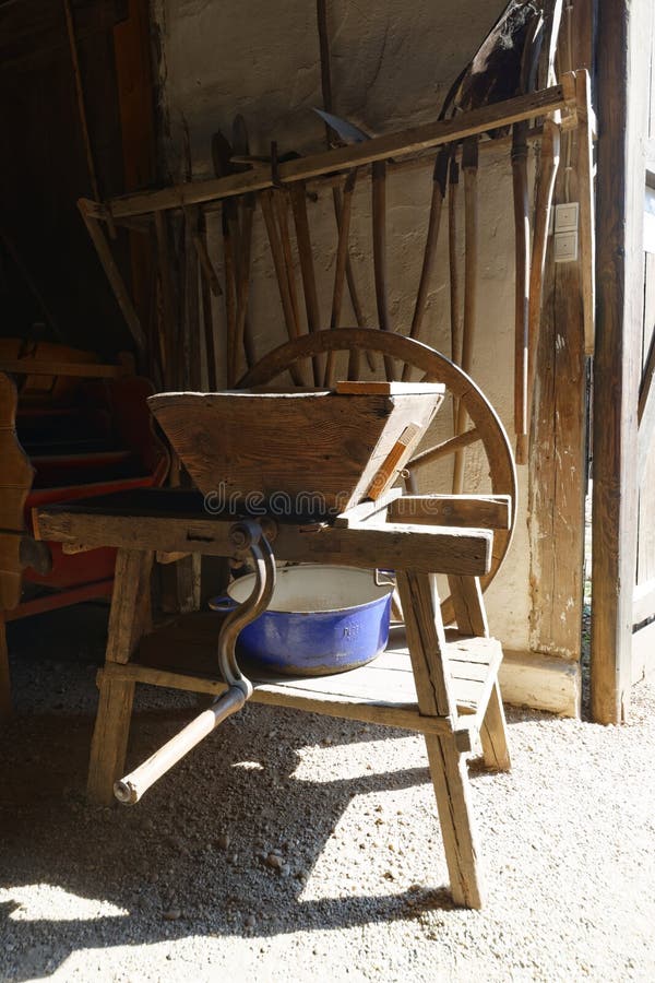 A hand operated agricultural grinding mill in a barn. A hand operated agricultural grinding mill in a barn.