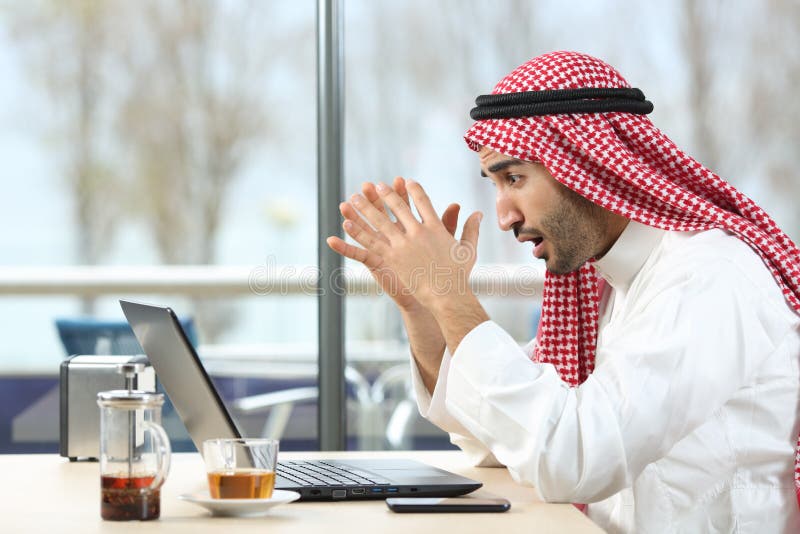Szokujący arabski mężczyzna sprawdza laptop w barze zdjęcia royalty free Szokujący arabski mężczyzna sprawdza laptop w barze zdjęcia royalty free