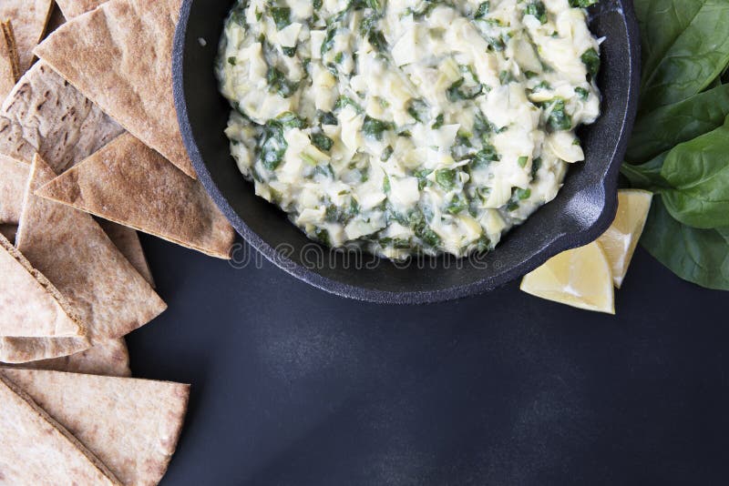 Pan with fresh vegan spinach artichoke dip and whole wheat pita bread. Pan with fresh vegan spinach artichoke dip and whole wheat pita bread