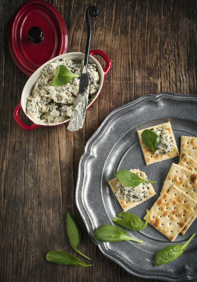 Spinach dip and crackers on wooden table. Spinach dip and crackers on wooden table