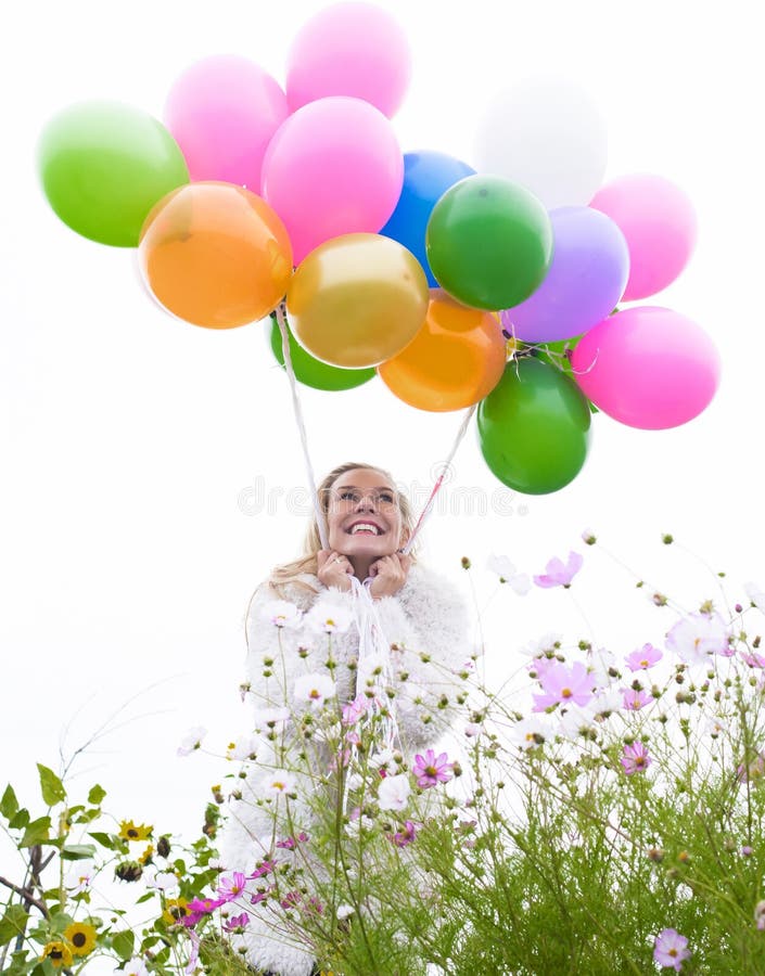 Blonde woman with balloons on a field of flowers. Blonde woman with balloons on a field of flowers