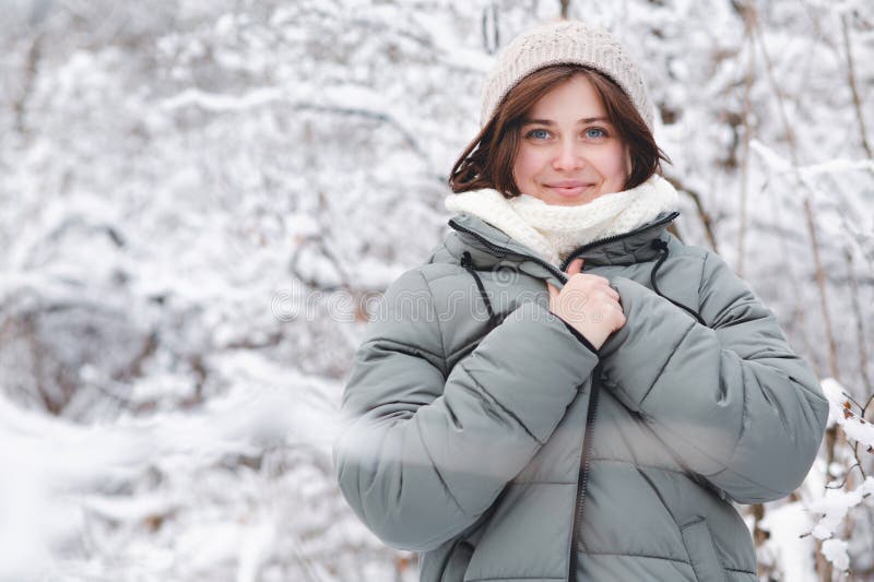 Sämre unga kvinnor i vinterkläder bland träd täckta med snöflicka som går i snöskog och njuter av vackra naturområden royaltyfri fotografi