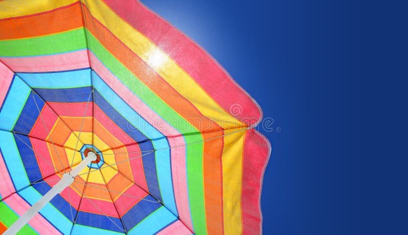 Colorful beach umbrella on a sunny summer day. Copy space. Colorful beach umbrella on a sunny summer day. Copy space.