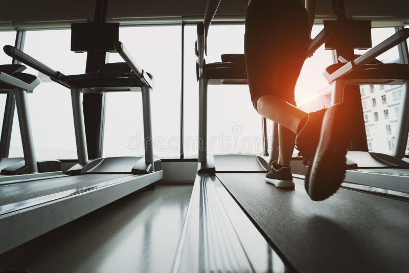 Séance d'entraînement courante de tapis roulant d'exercice cardio- au gymnase de forme physique de la femme prenant la perte de p photo libre de droits Séance d'entraînement courante de tapis roulant d'exercice cardio- au gymnase de forme physique de la femme prenant la perte de p photo libre de droits