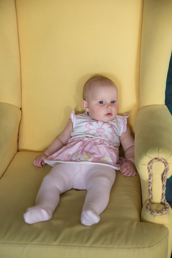 Séance de bébé sur le grand fauteuil dans le studio images stock Séance de bébé sur le grand fauteuil dans le studio images stock