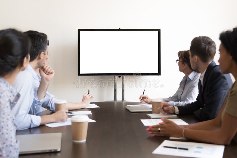 Séance de groupe d'hommes d'affaires à la table de conférence regardant l'écran