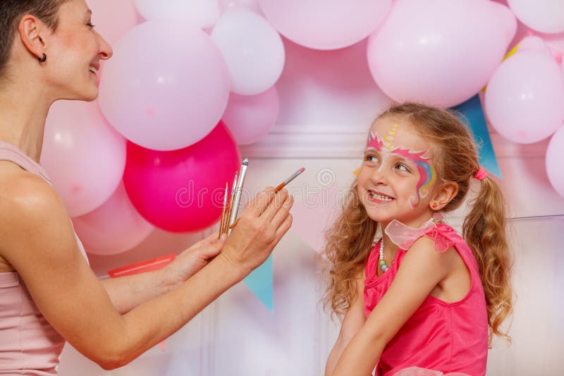 Séance joyeuse de peinture faciale pour une jeune fille à l'événement festif images stock