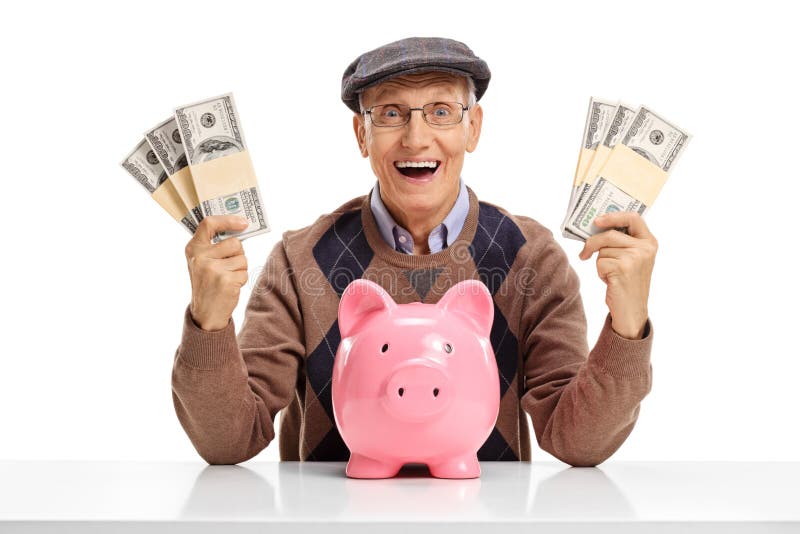Sênior alegre com os pacotes de dinheiro e de piggybank na tabela imagens de stock Sênior alegre com os pacotes de dinheiro e de piggybank na tabela imagens de stock