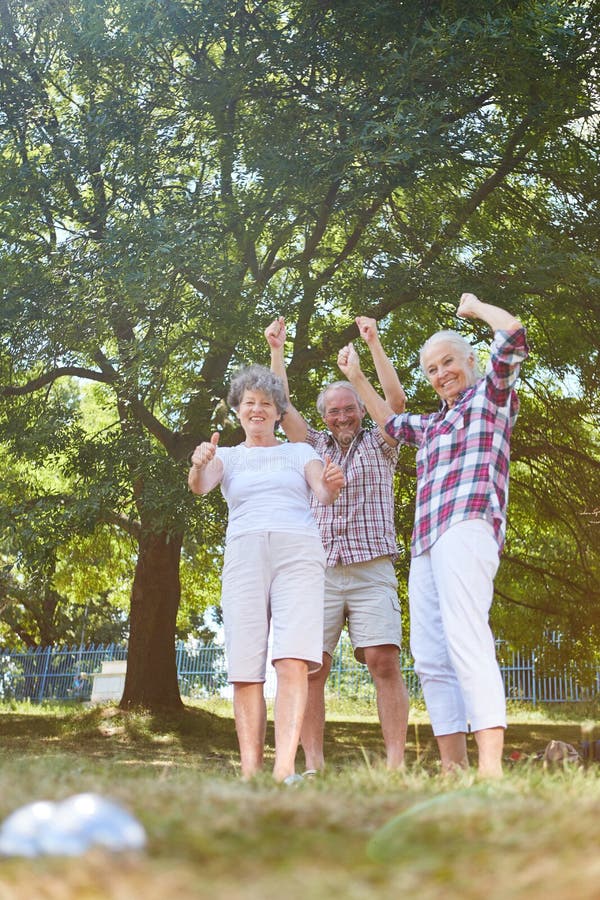 Sêniores ativos que cheering ao jogar boules foto de stock Sêniores ativos que cheering ao jogar boules foto de stock