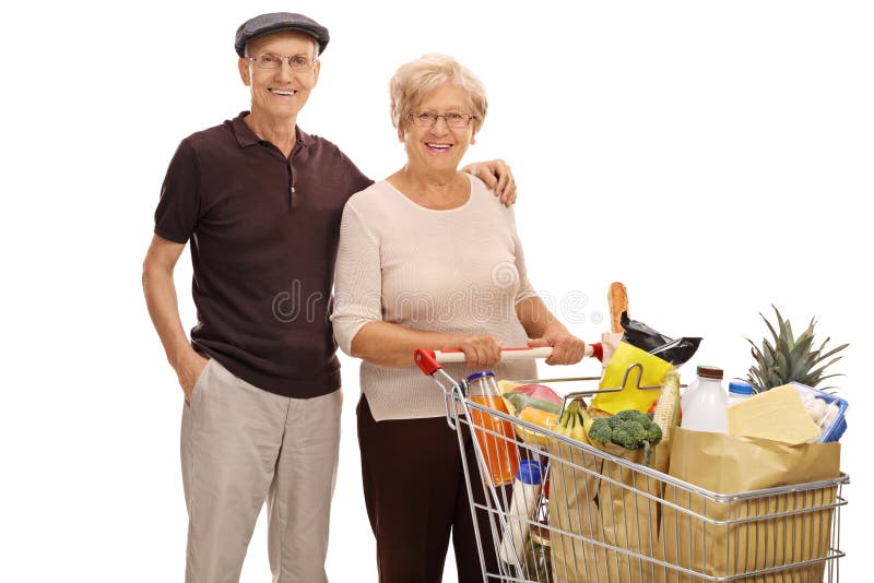 Sêniores com um carrinho de compras completo dos mantimentos foto de stock Sêniores com um carrinho de compras completo dos mantimentos foto de stock
