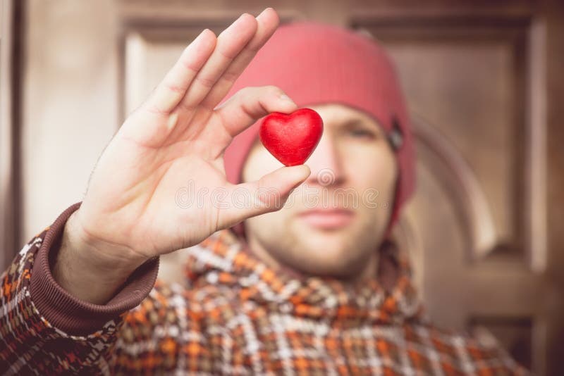 Símbolo del amor de la forma del corazón en mano del hombre con la cara en el saludo romántico del día de tarjetas del día de San imagen de archivo libre de regalías Símbolo del amor de la forma del corazón en mano del hombre con la cara en el saludo romántico del día de tarjetas del día de San imagen de archivo libre de regalías