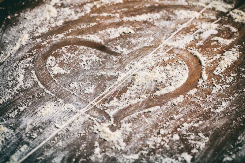 Símbolo del corazón en fondo de la harina imagenes de archivo Símbolo del corazón en fondo de la harina imagenes de archivo