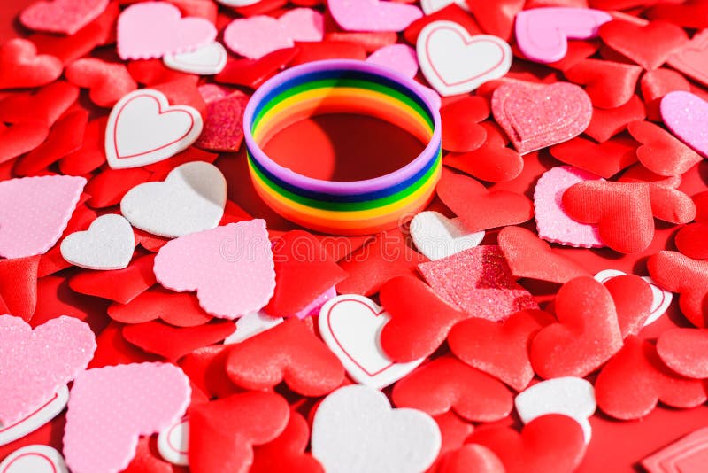 Símbolo LGBT multicolor sobre un fondo de corazones rojos románticos, San Valentín para parejas del mismo sexo imagenes de archivo Símbolo LGBT multicolor sobre un fondo de corazones rojos románticos, San Valentín para parejas del mismo sexo imagenes de archivo
