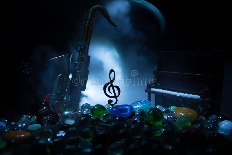 Símbolo musical trble clef clef miniatura de acero inoxidable con luz de tonalidad colorida sobre fondo de niebla. foco selectivo