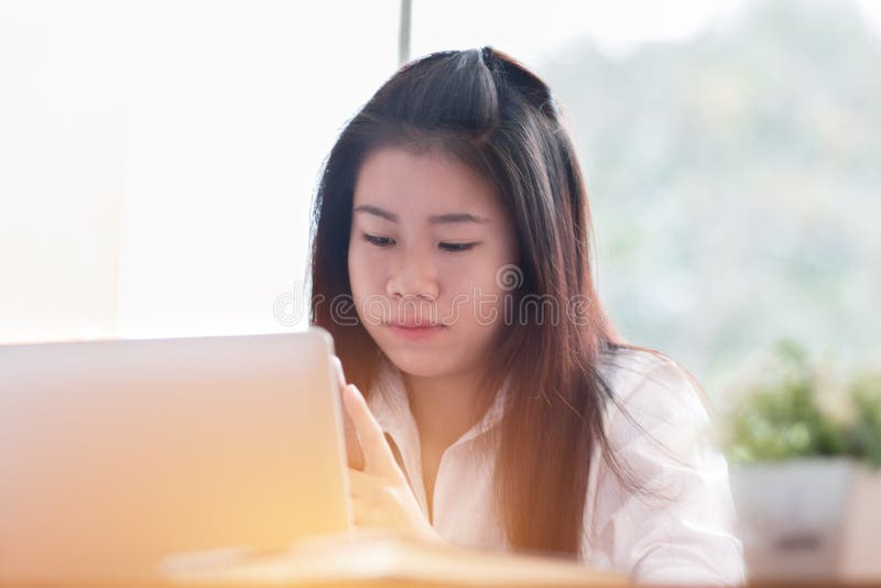 Sök efter sociala nätverk online med Smartphone Concept: Asiatisk Cute Woman med smartphone och bärbar dator för att handla eller royaltyfri fotografi Sök efter sociala nätverk online med Smartphone Concept: Asiatisk Cute Woman med smartphone och bärbar dator för att handla eller royaltyfri fotografi