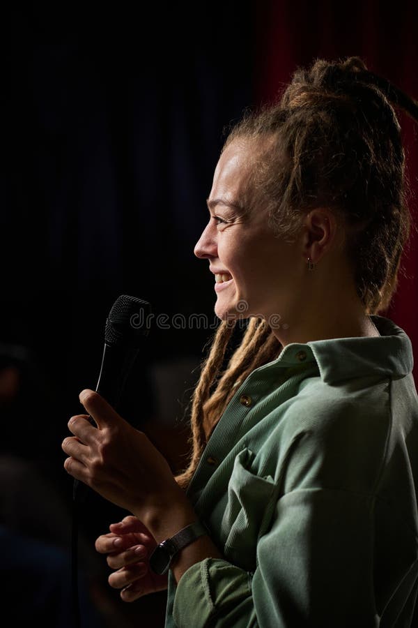Sömma kvinnor med Braids Holding Microphone på scenen royaltyfri fotografi