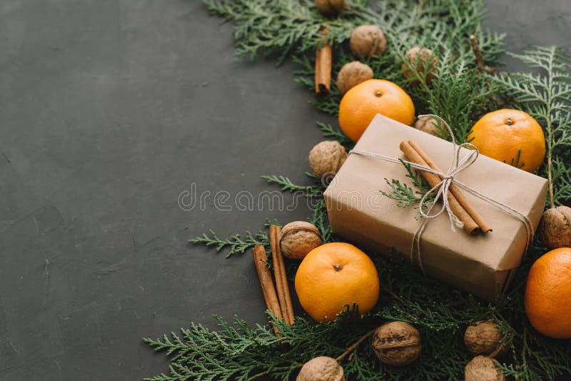 Sörjer sammansättning för det nya året för jul med tangerinaskar kottegräsplaner i svart tonad bakgrundsferiegarnering royaltyfri fotografi