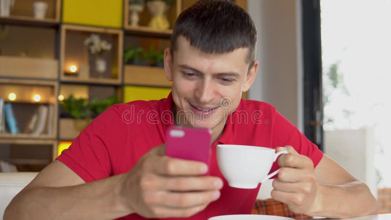 Söt kopp för giffel för bakgrundsavbrottskaffe Man som använder mobiltelefonen, medan dricka kaffe lager videofilmer