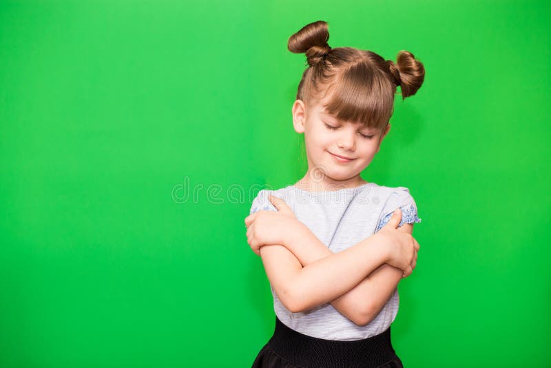 Söt liten flicka gnäller sig själv som leende och glad. arkivfoton