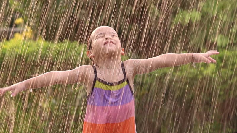 Söt liten flicka som har kul på bakgården. barn får utomhusaktiviteter under varma sommardagar. lager videofilmer