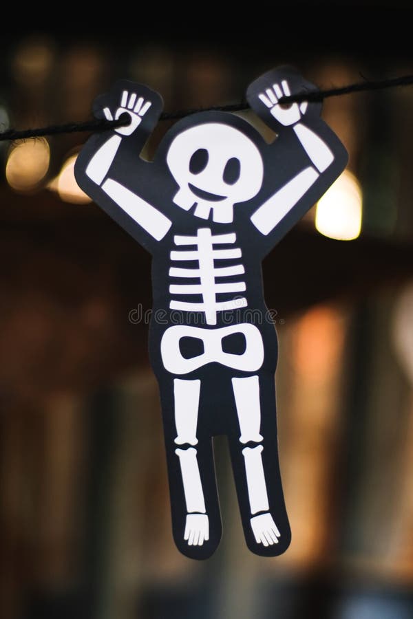 Söt vitt skelettben hängande med svart rep med oskarp bakgrund halloween helgfestival royaltyfria bilder