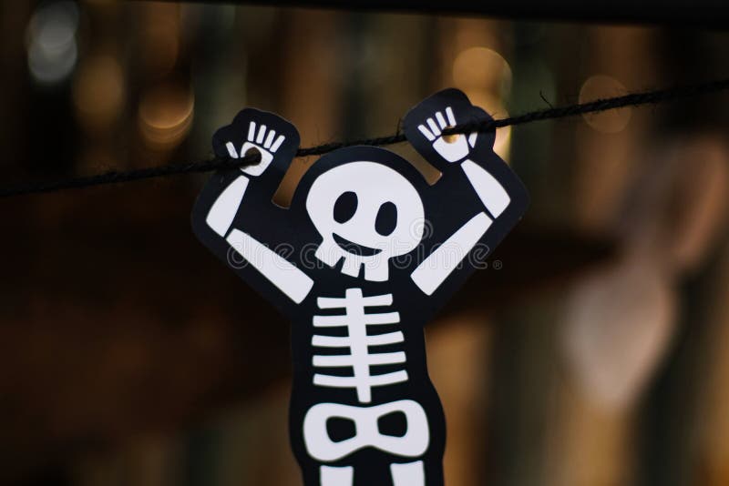 Söt vitt skelettben hängande med svart rep med oskarp bakgrund halloween helgfestival royaltyfri bild