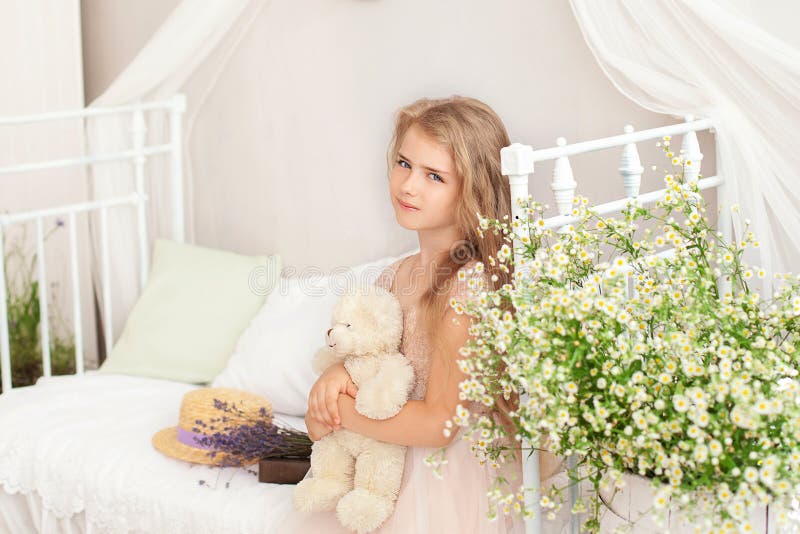 Söta, blonde lilla flicka kraggar teddy björnutrymme. rumsliknande provrum inåt. barnomsorg. barnkrabbor, tedybjörn, utseende royaltyfria foton