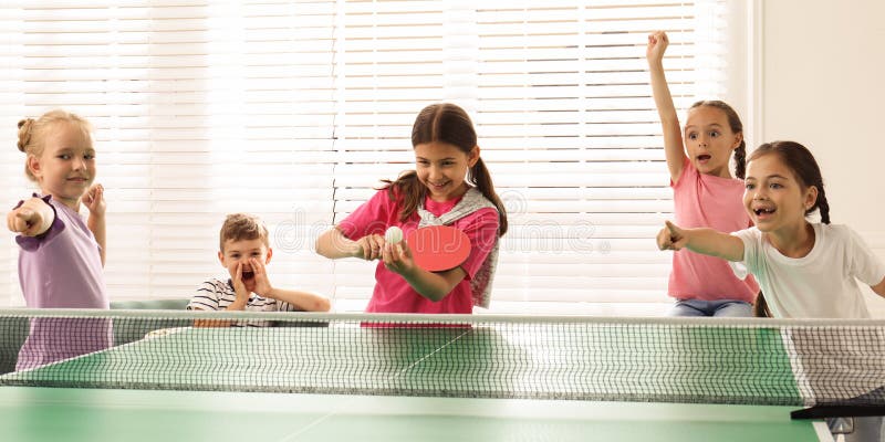 Süße Kinder spielen Tischtennis drinnen. Banner lizenzfreie stockbilder