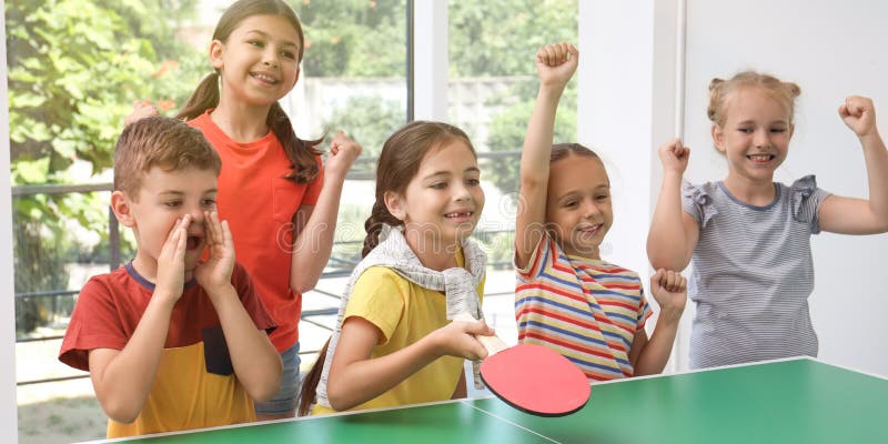 Süße Kinder spielen Tischtennis drinnen. Banner lizenzfreie stockbilder