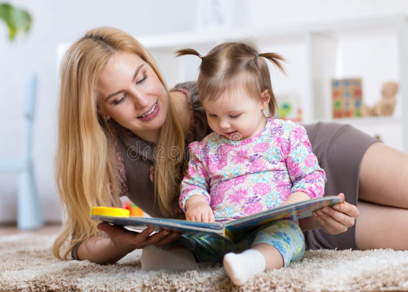 Süßes Baby mit Mutterlesebuch in der Kindertagesstätte stockfoto Süßes Baby mit Mutterlesebuch in der Kindertagesstätte stockfoto