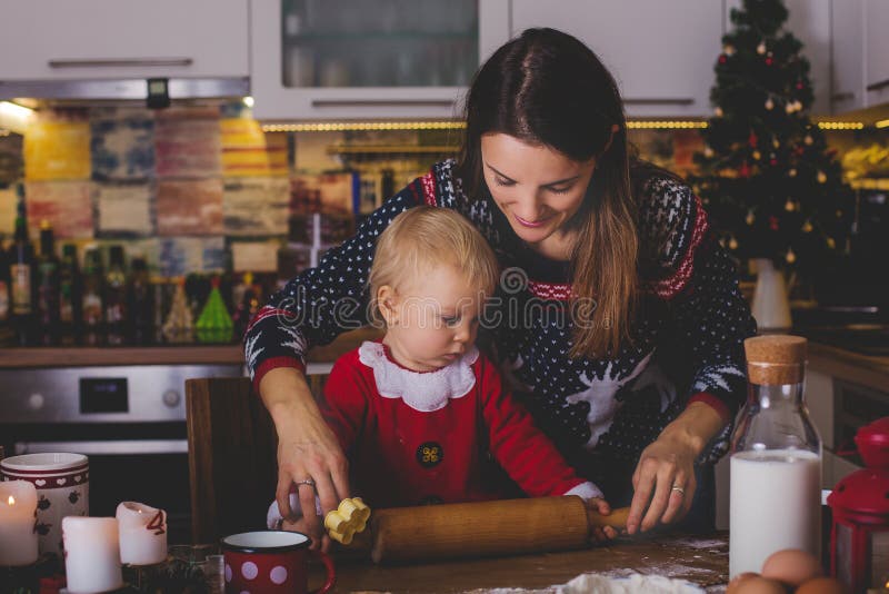 Süßes Kleinkindkind, Junge, helfende Mama, die Weihnachtskoch vorbereitet lizenzfreie stockfotografie Süßes Kleinkindkind, Junge, helfende Mama, die Weihnachtskoch vorbereitet lizenzfreie stockfotografie