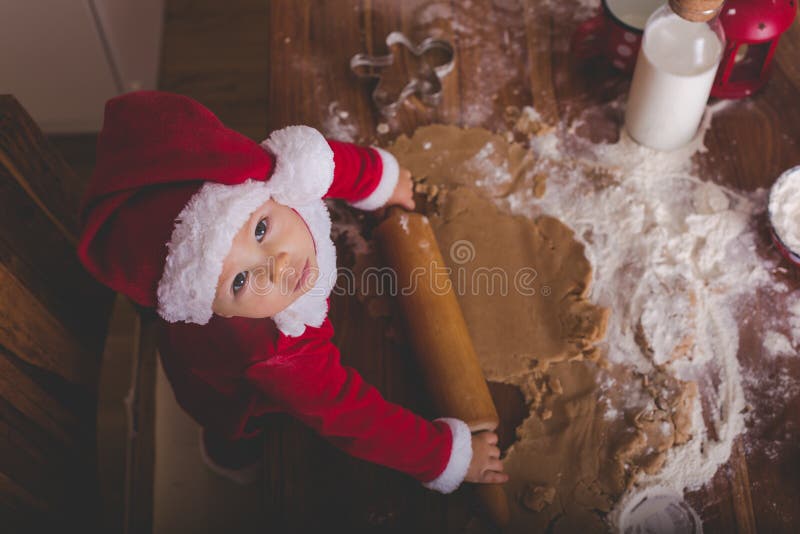 Süßes Kleinkindkind, Junge, helfende Mama, die Weihnachtskoch vorbereitet lizenzfreie stockfotografie Süßes Kleinkindkind, Junge, helfende Mama, die Weihnachtskoch vorbereitet lizenzfreie stockfotografie