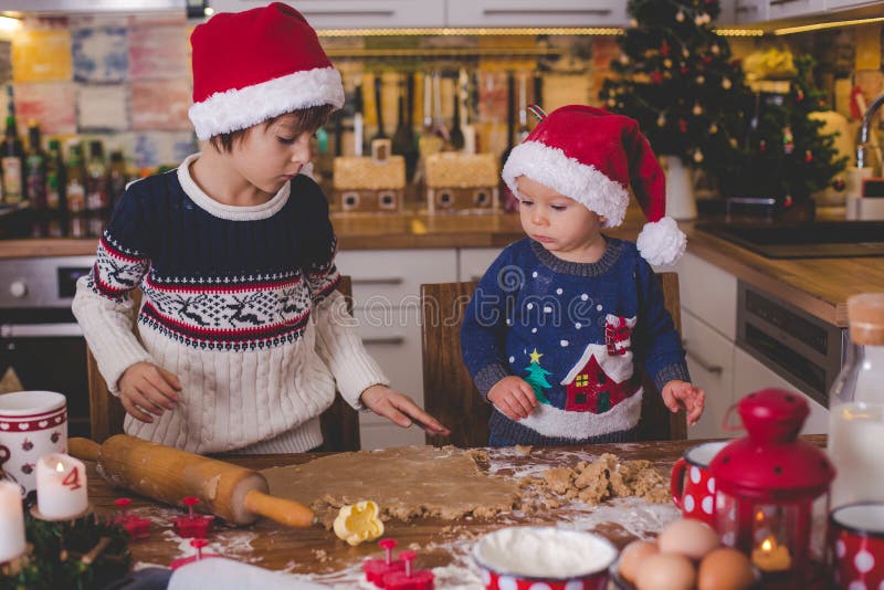 Süßes Kleinkindkind und sein älterer Bruder, Jungen, helfende Mama p lizenzfreie stockbilder Süßes Kleinkindkind und sein älterer Bruder, Jungen, helfende Mama p lizenzfreie stockbilder