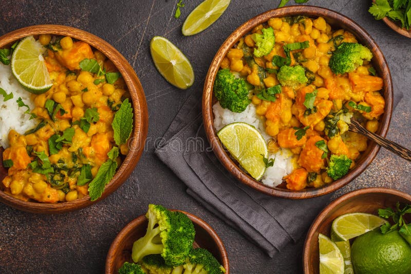 Süßkartoffel-Kichererbsencurry des strengen Vegetariers in der hölzernen Schüssel auf einem dunklen backg stockbild Süßkartoffel-Kichererbsencurry des strengen Vegetariers in der hölzernen Schüssel auf einem dunklen backg stockbild