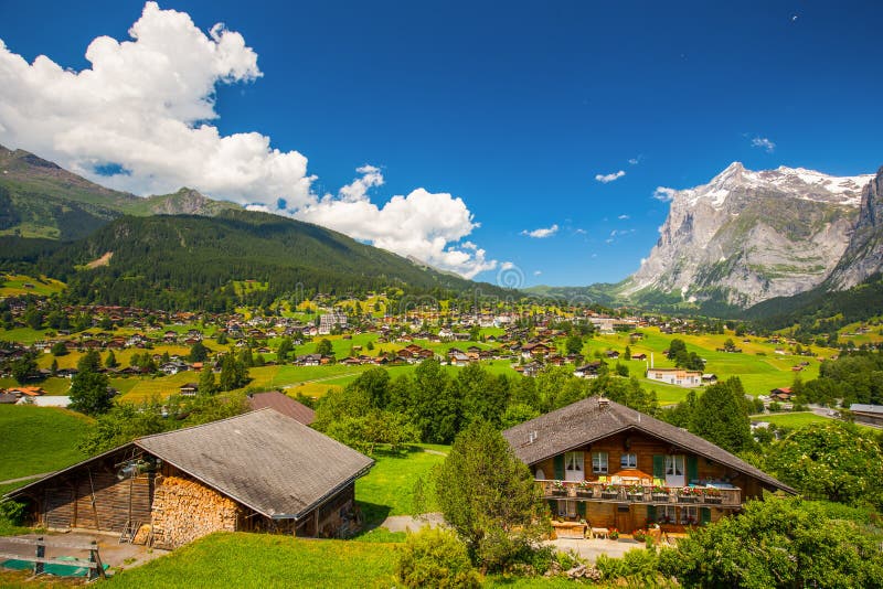 View to famous Grindelwald valley, green forest, Alps chalets and Swiss Alps (Schreckhorn, Berglistock and Wetterhorn) in the background, Berner Oberland, Switzerland, Europe. View to famous Grindelwald valley, green forest, Alps chalets and Swiss Alps (Schreckhorn, Berglistock and Wetterhorn) in the background, Berner Oberland, Switzerland, Europe.