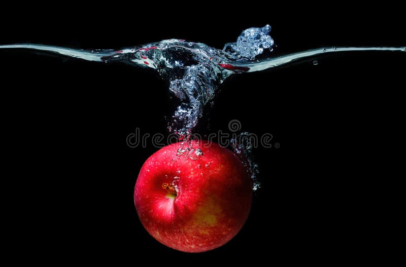 Fresh red apple dropped in water with splashes isolated on black background. Fresh red apple dropped in water with splashes isolated on black background