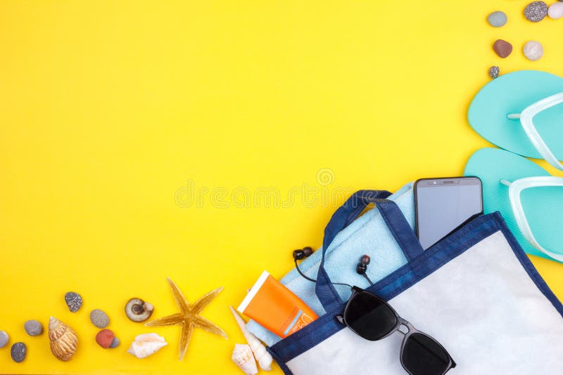 Słońc szkła, słońce ekran, hełmofony, smartphone, ręcznik, kapcie Flatlay plaży wakacje na żółtym tle fotografia stock Słońc szkła, słońce ekran, hełmofony, smartphone, ręcznik, kapcie Flatlay plaży wakacje na żółtym tle fotografia stock