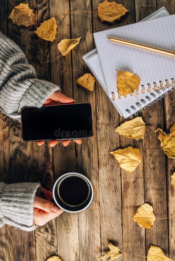 Headphones with autumn dry leaves, cuo of coffee and notepads on rustic wooden background. Top view. Flat lay. Headphones with autumn dry leaves, cuo of coffee and notepads on rustic wooden background. Top view. Flat lay