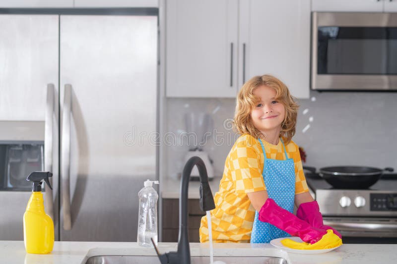 Une Petite Fille Essuie La Vaisselle Dans La Cuisine. Bébé Fait Des Travaux  Ménagers à La Maison.