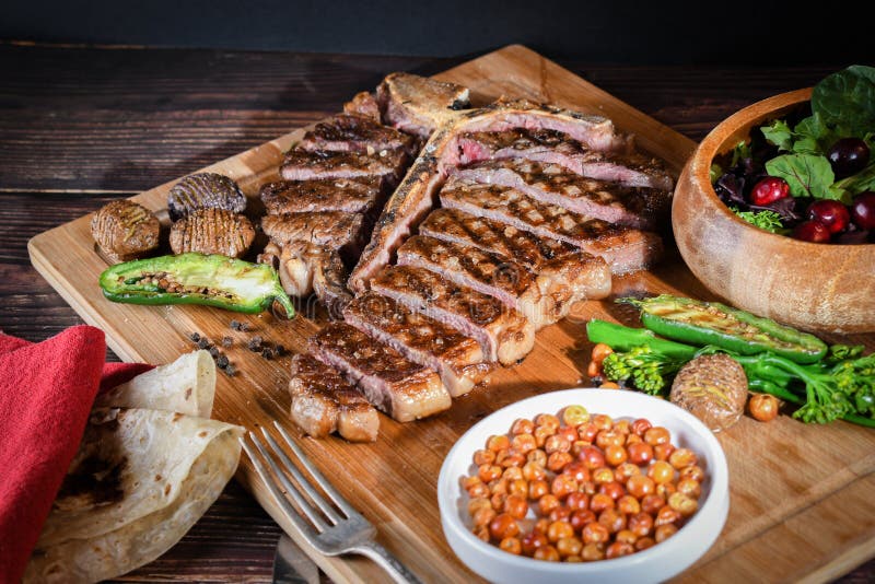 T bone Steak or Porterhouse Grilled in Pieces on Wood with Hot Pepper