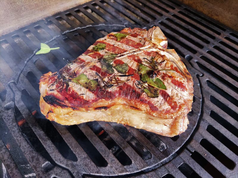 Tbone Steak Flavored with Herbs Cooks on the Grill Stock Photo Image