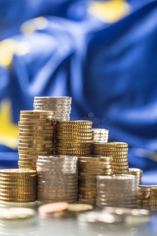 T?rme mit Eurom?nzen und Flagge der Europ?ischer Gemeinschaft im Hintergrund lizenzfreie stockfotografie T?rme mit Eurom?nzen und Flagge der Europ?ischer Gemeinschaft im Hintergrund lizenzfreie stockfotografie